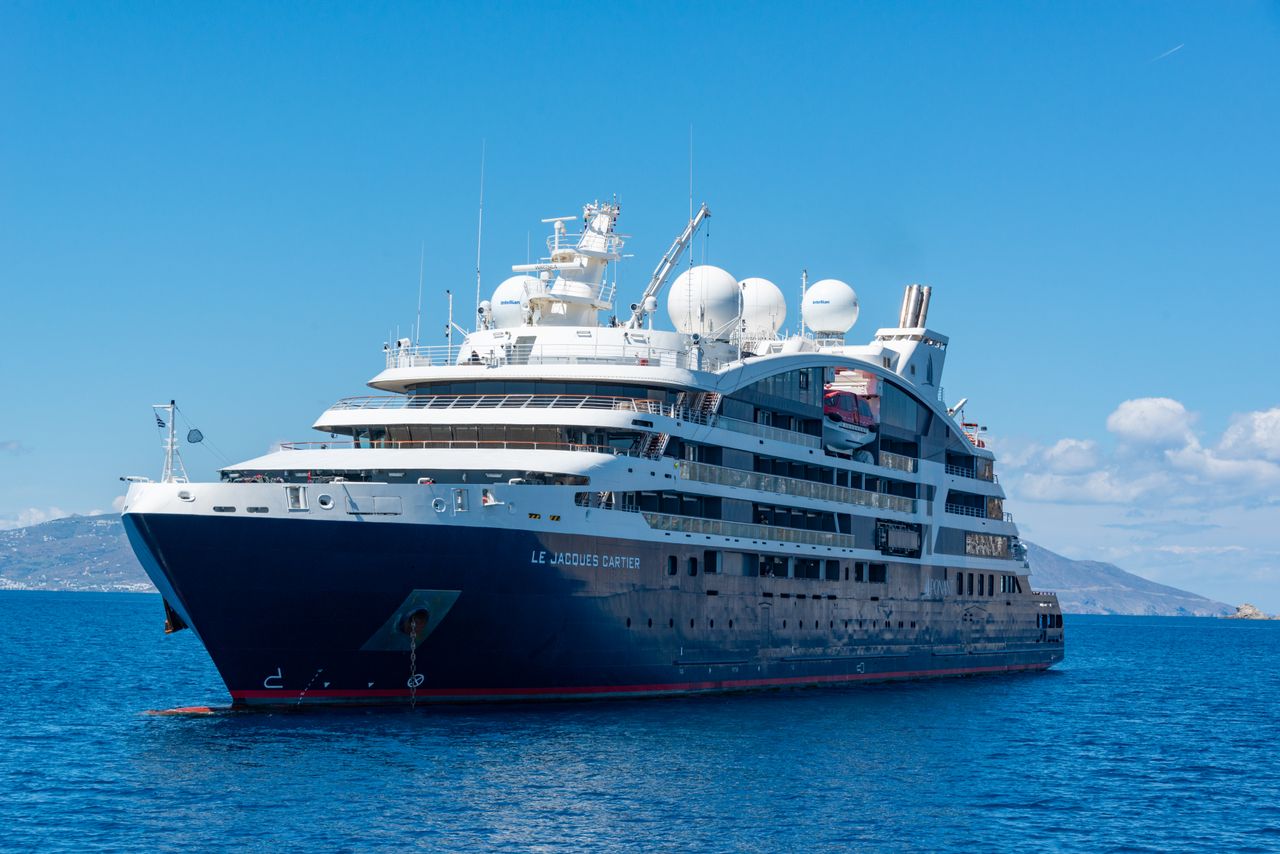 digital A luxury cruise ship sailing on open blue waters under a clear sky.